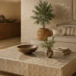 Elegant contemporary living room featuring a handcrafted ceramic coffee table, textured ceramic wall tiles, organic furnishings, natural wood cabinetry, and Mediterranean-inspired interior design with warm neutral tones.